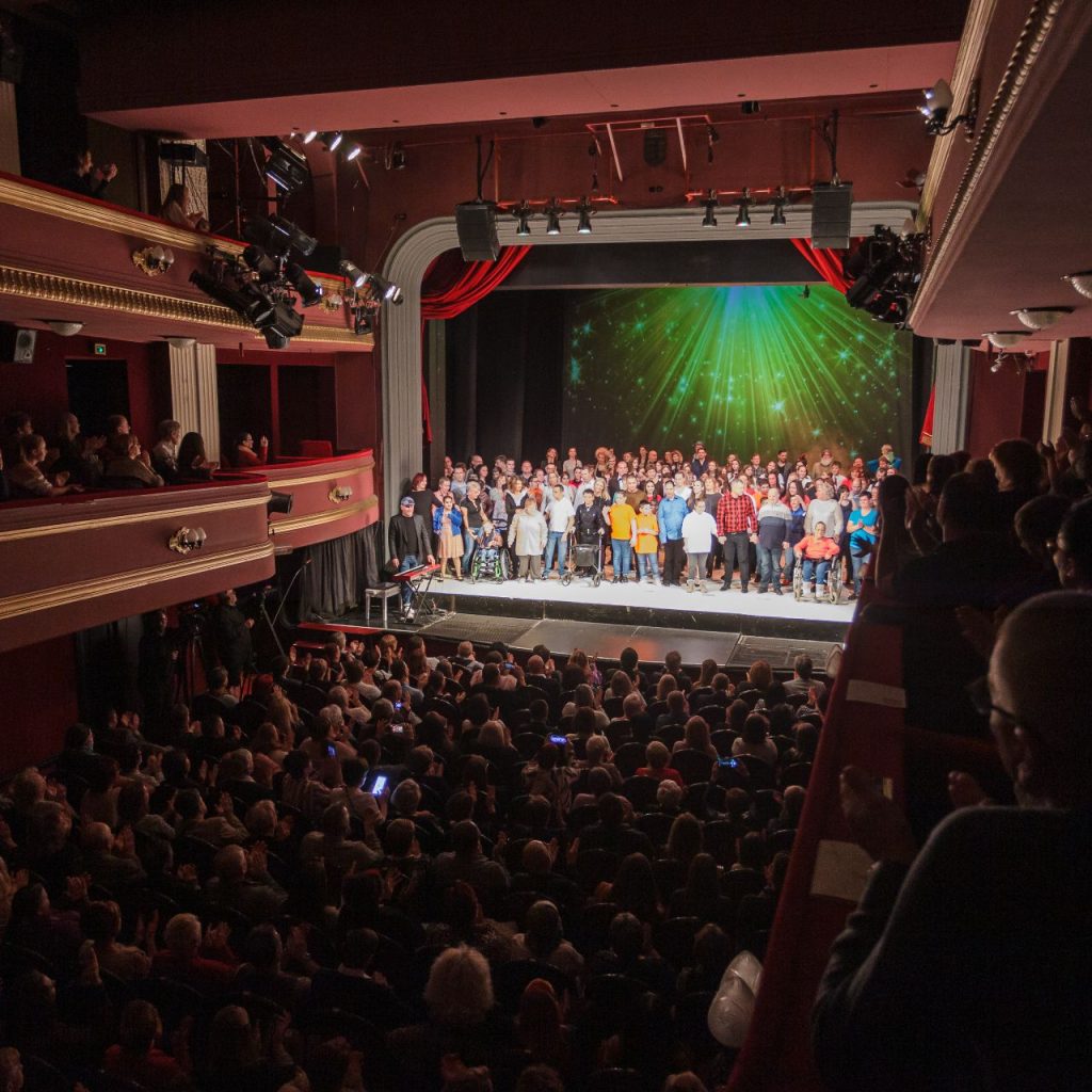 Az Angyalok szárnyalása című előadás szereplői közösen a színpadon, a nézők felé fordulva ünnepelnek.