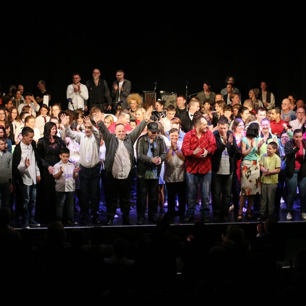 Az Angyalok Szárnyalása című előadás szereplői közösen a színpadon, a nézők felé fordulva ünnepelnek.