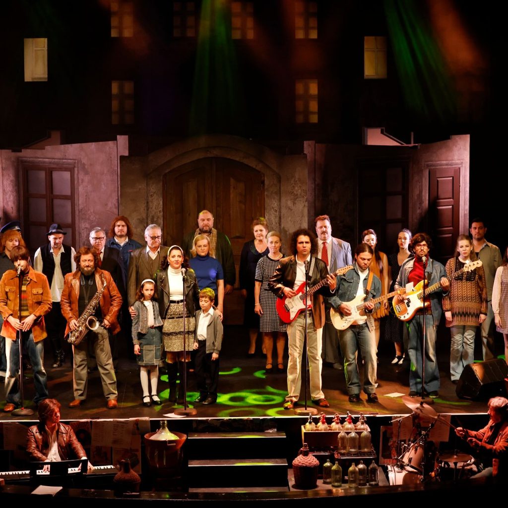 Azok a boldog szép napok című színházi előadás szereplői a színpadon, hangszeres zenészekkel.