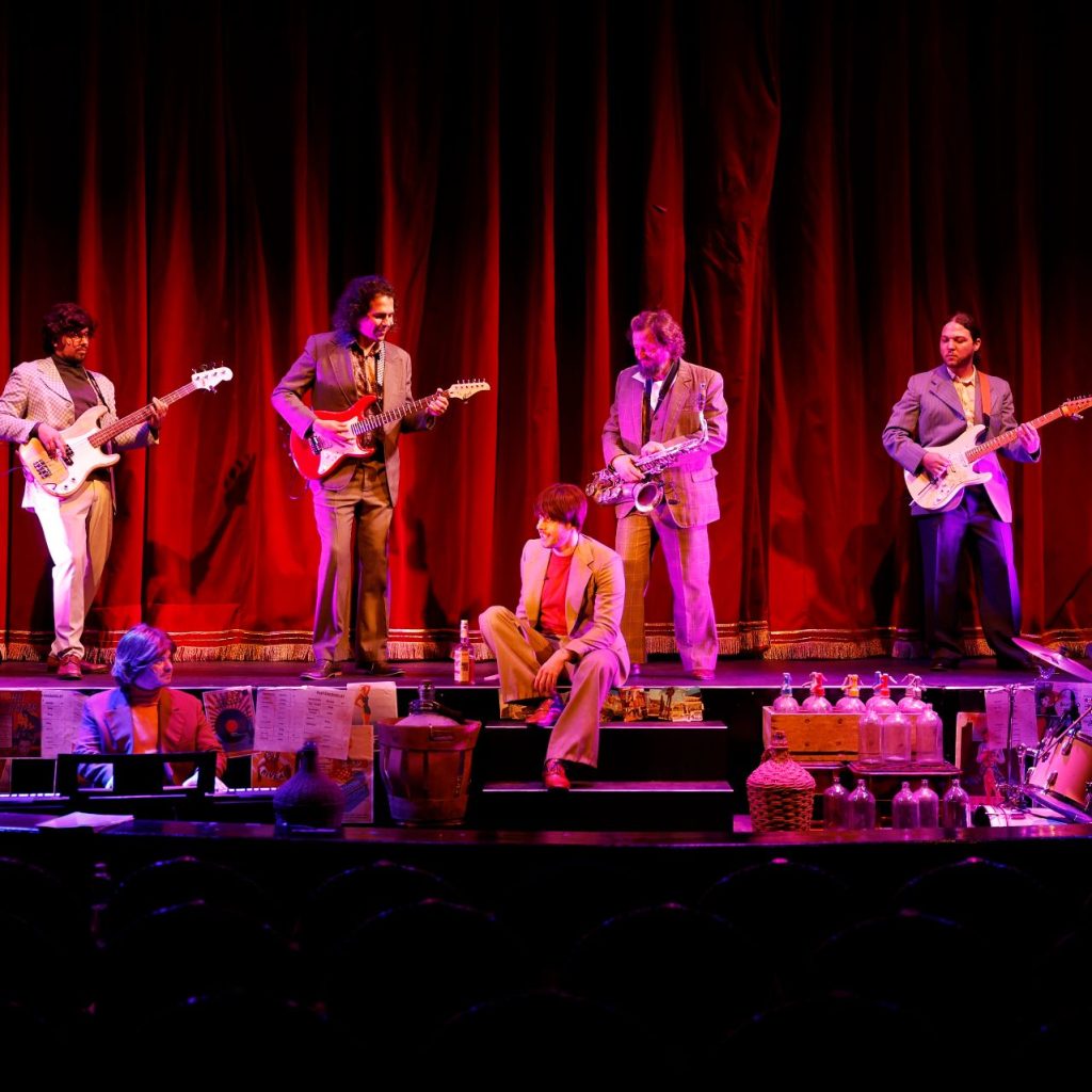 Azok a boldog szép napok című színházi előadás szereplői a színpadon, hangszeres zenészekkel.