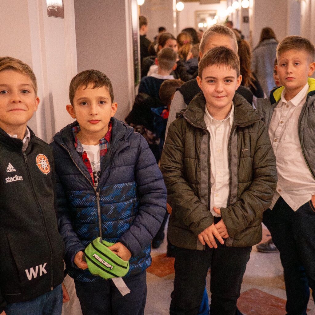 Négy kisfiú áll a képen, a kamerába mosolyognak