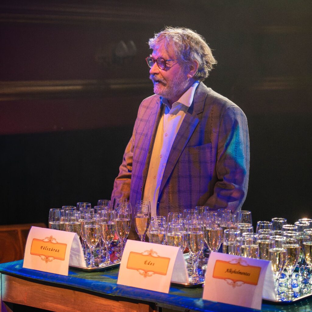 Seregi Zoltán igazgató úr van a képen, előtte pezsgős poharak