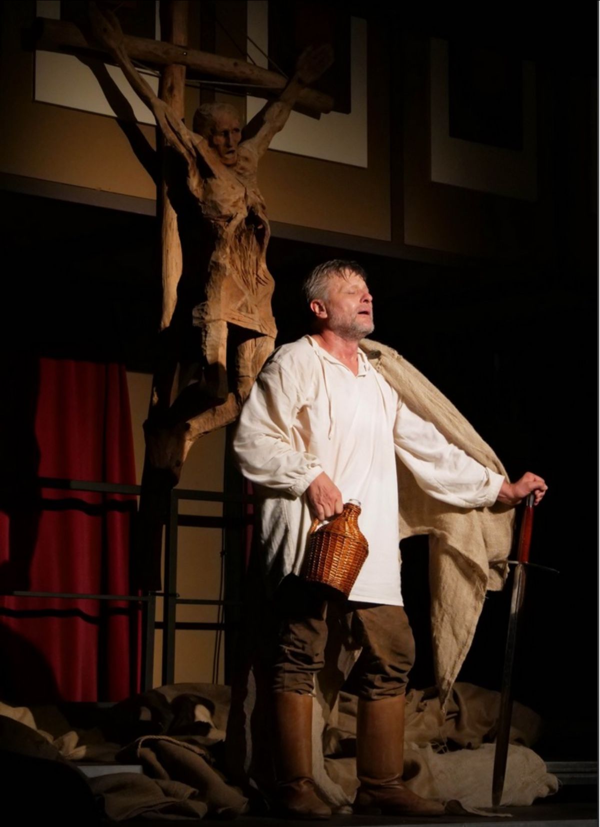 A színművész a Dózsa című darabban jelenet közben, demizsont fog a kezében.