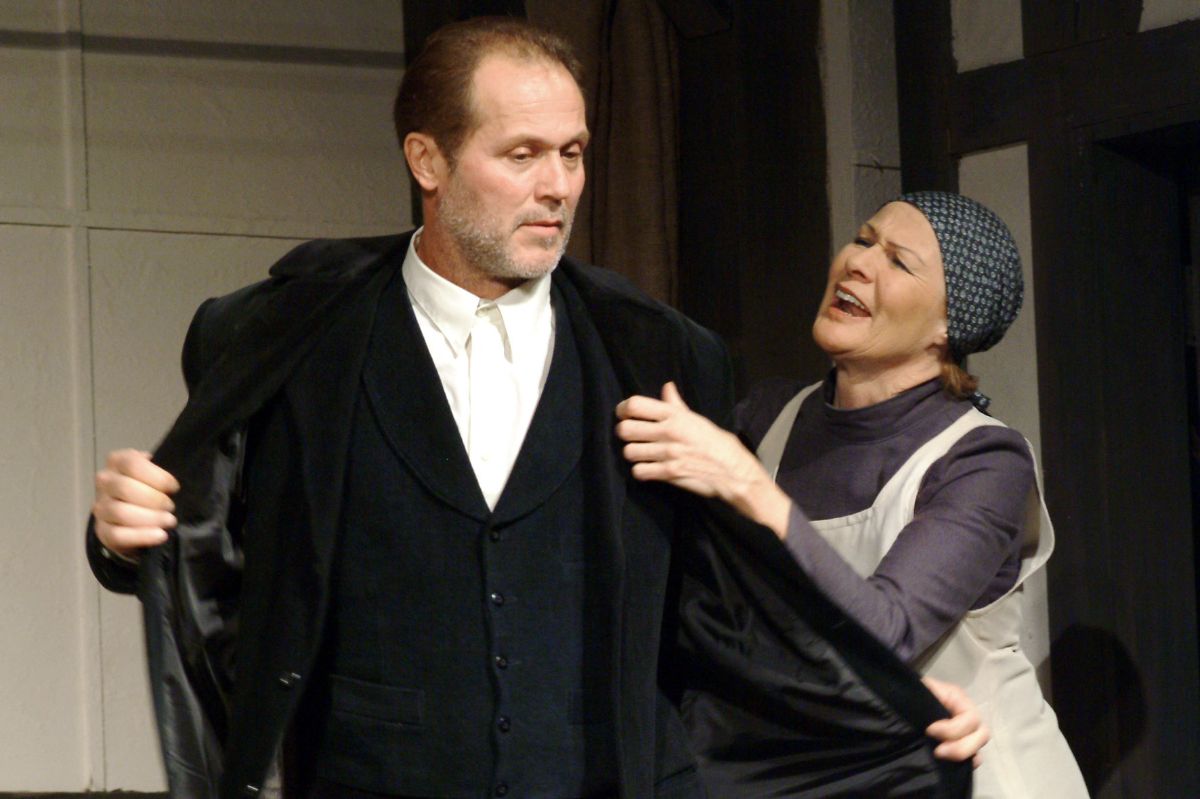 A színművészek a Egy lócsiszár virágvasárnapja című darabban párbeszédet folytatnak a színpadon.