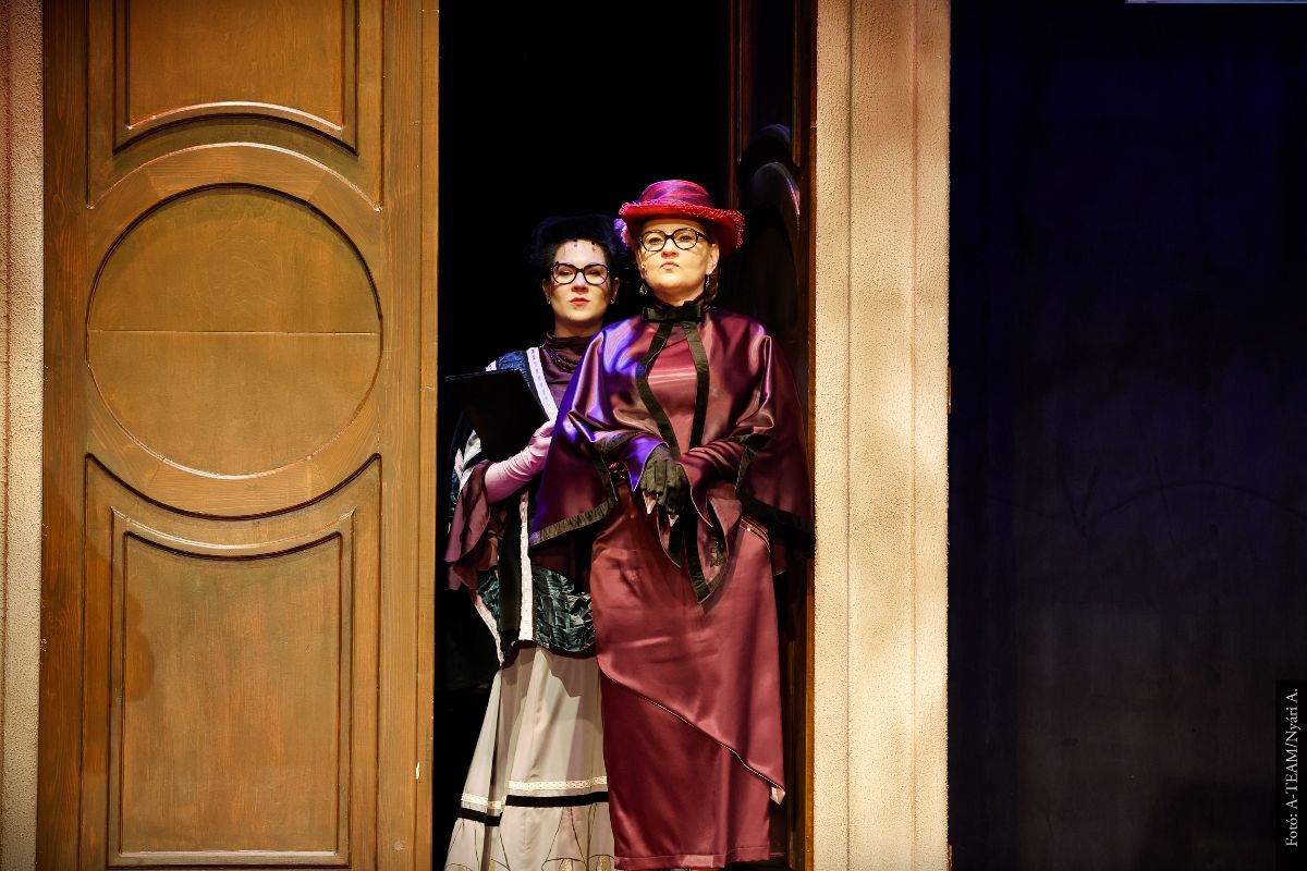 A színművészek A bolondok grófja című előadásban jelenet közben a színpadon belépnek az ajtón.