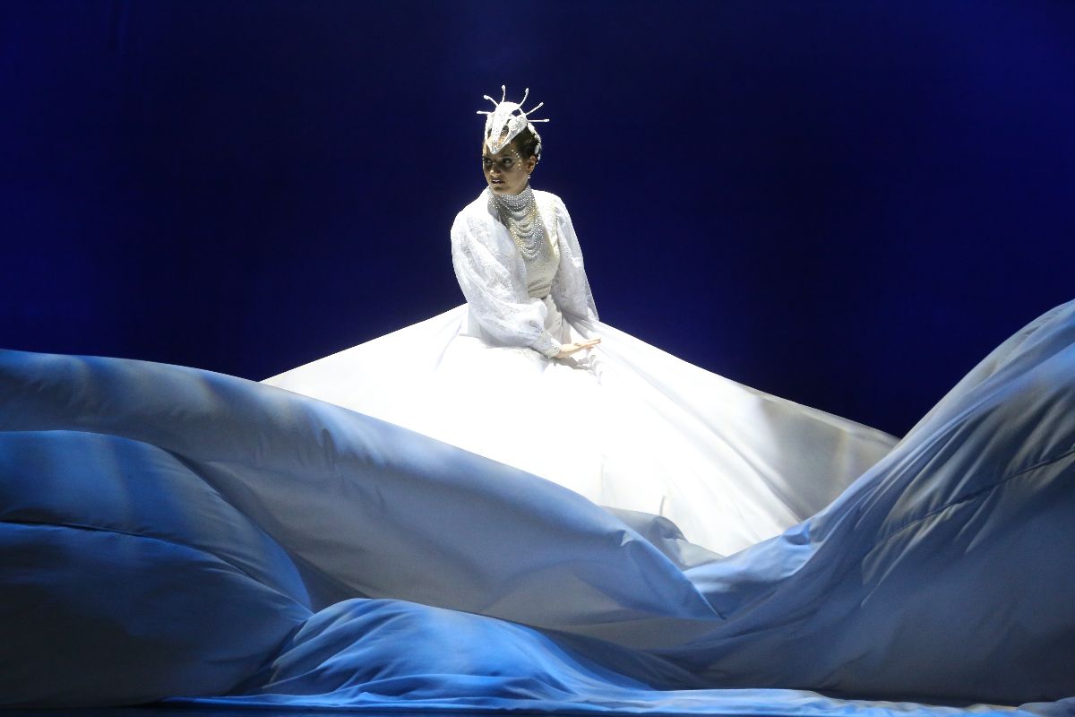 A színművész a Fehérlófia című darabban jelenet közben a színpadon lebegő vászon között.