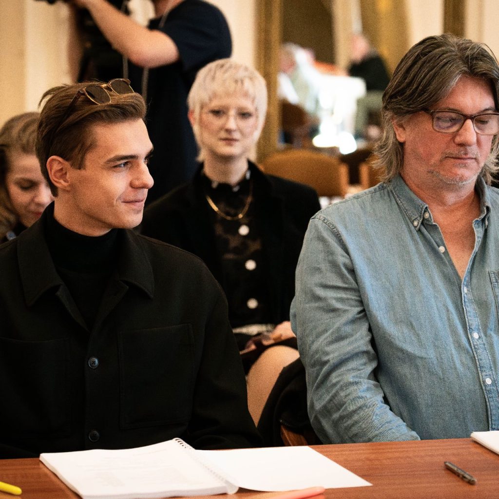 A Látni a láthatatlant című előadás olvasópróbáján két férfi ül egymás mellett, előttük jegyzetek és tollak az asztalon.