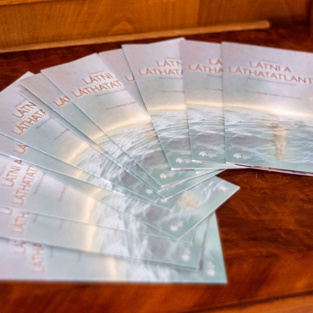 A képen a Látni a láthatatlant műsorfüzetei vannak szépen kiterítve egy íves sorban