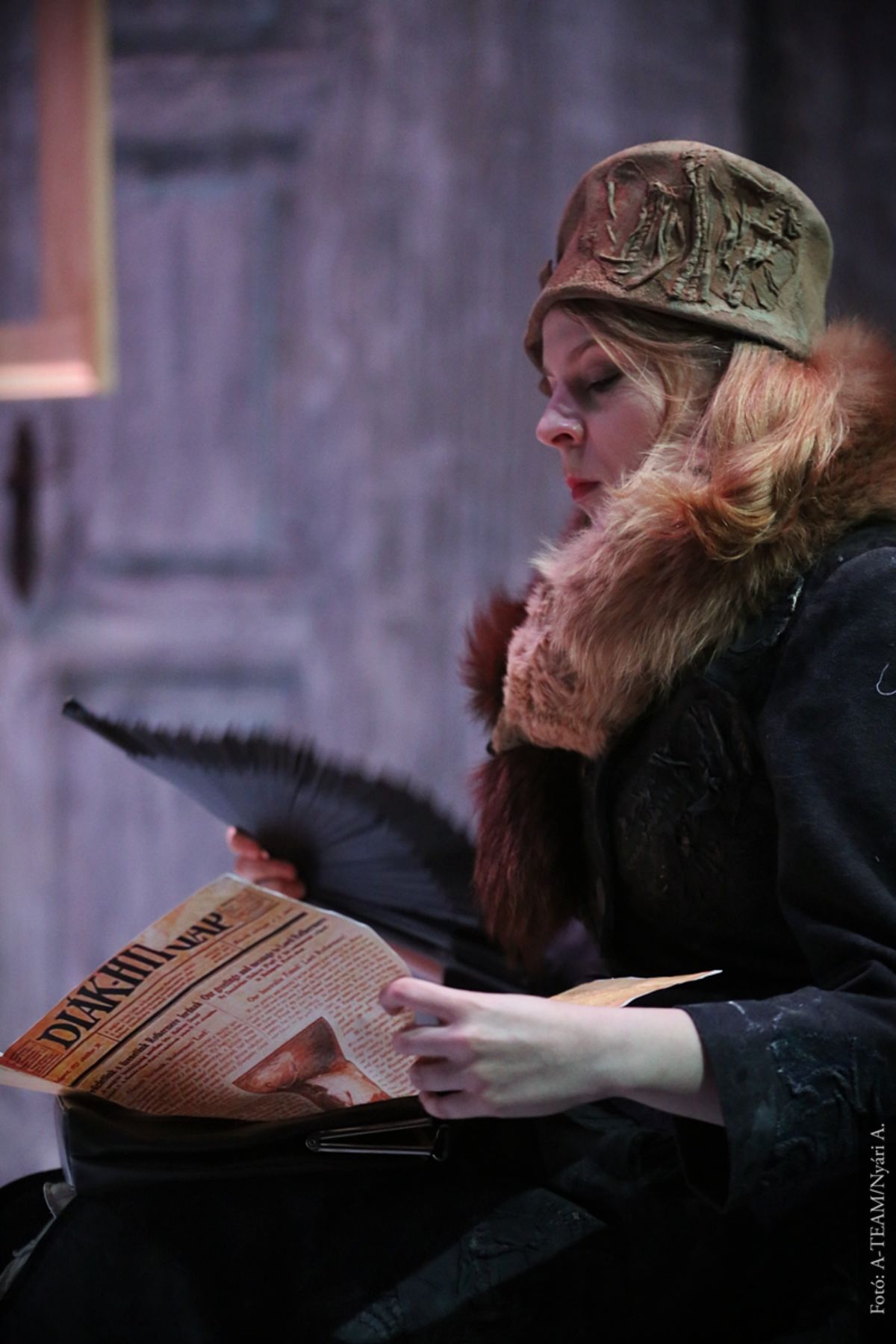 A színművész a Tizenhárom almafa című darabban jelenet közben olvas.