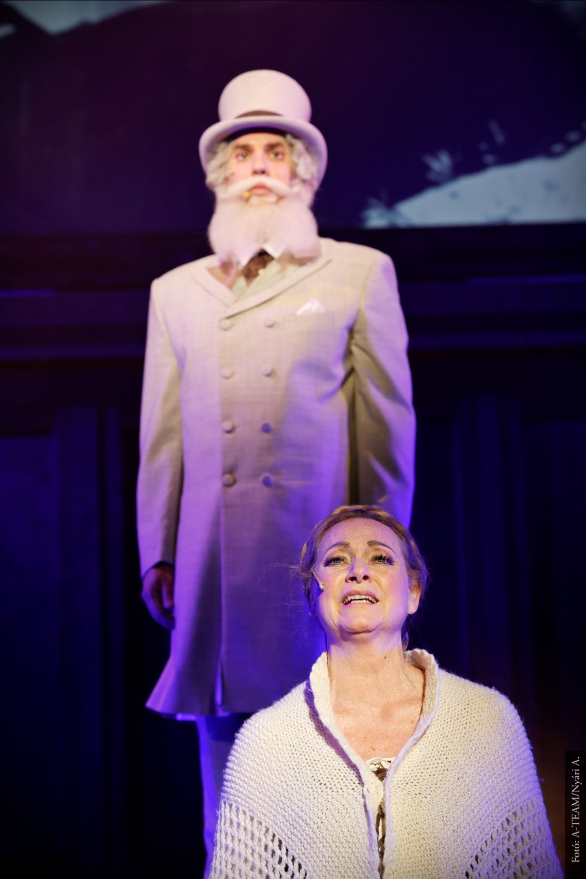A színművész a Munkácsy, a festőfejedelem című darabban jelenet közben énekel, mögötte a másik színművész figyel.