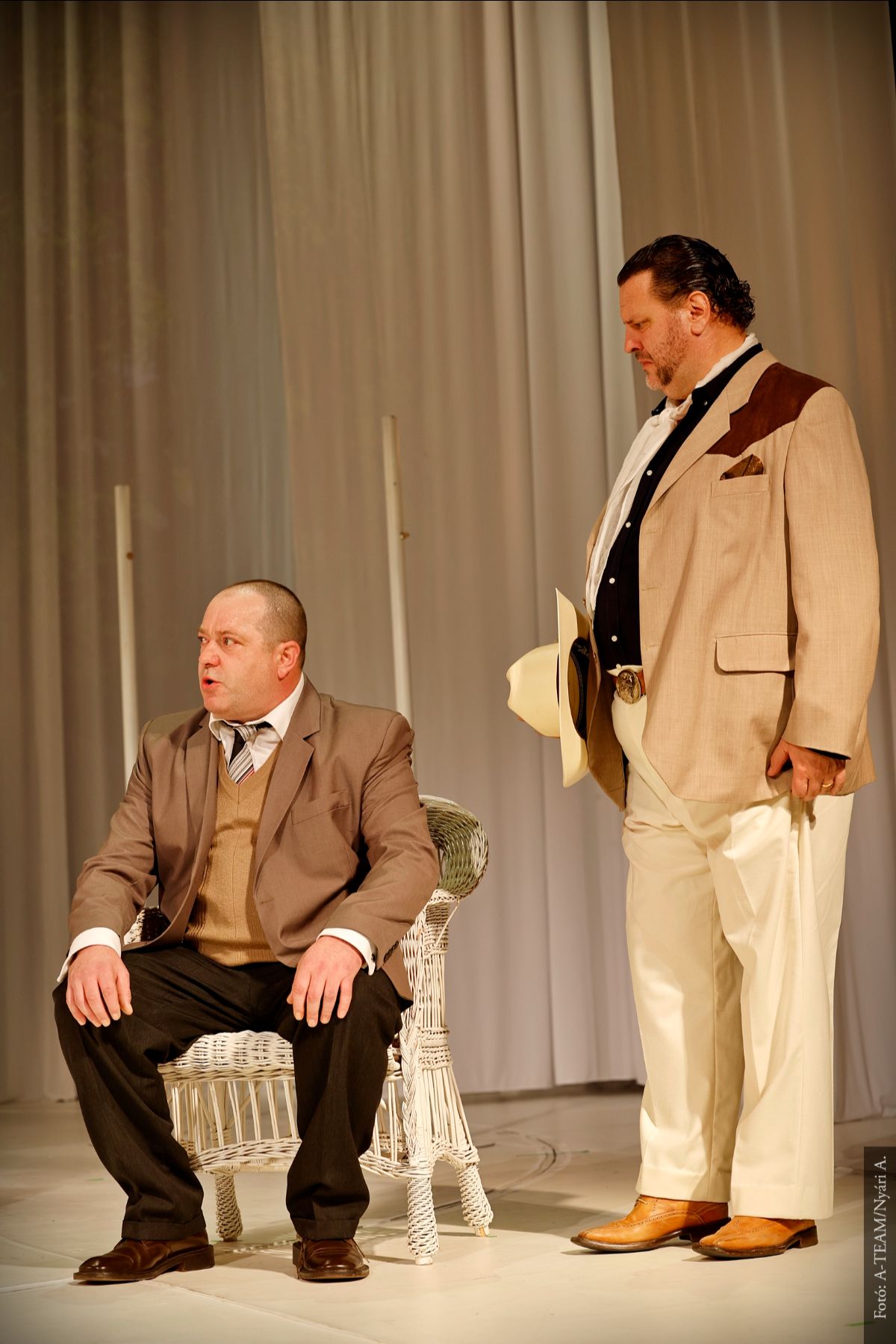 A színművészek A noszty fiú esete tót marival című darabban párbeszédet folytatnak a színpadon.